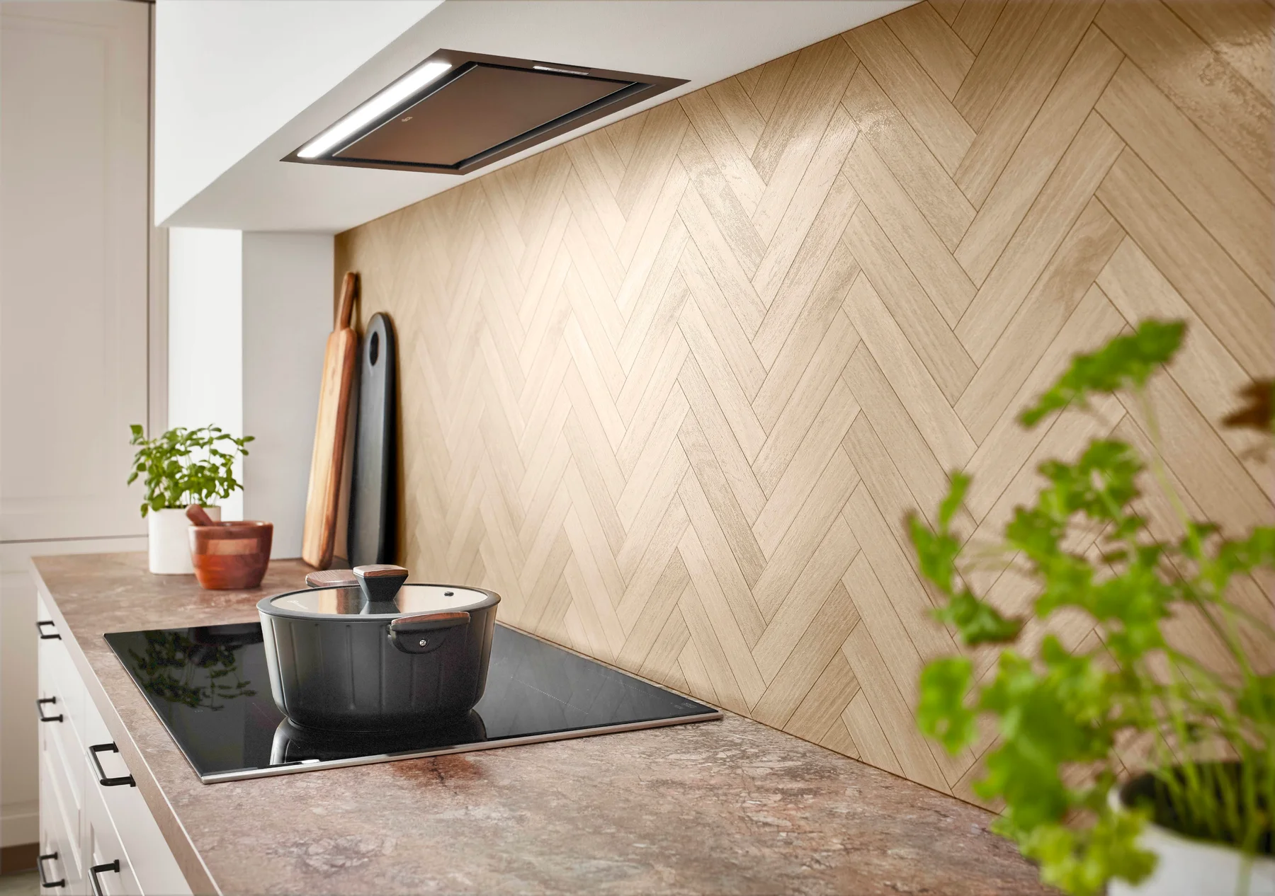 Kücheninspiration: Kochbereich mit heller Holzrückwand und integrierter Dunstabzugshaube